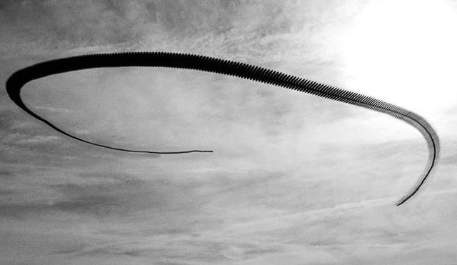 Xavi Bou, ornitographies, vol d'oiseaux qui forme une ligne courbe dans le ciel en noir et blanc. 