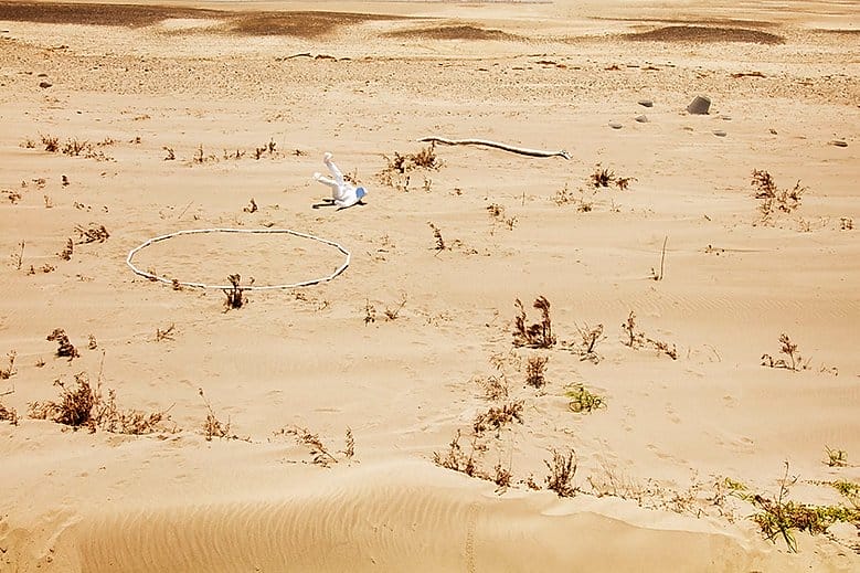 Yoshiki Hase, un homme en combinaison blanche dans le désert. 