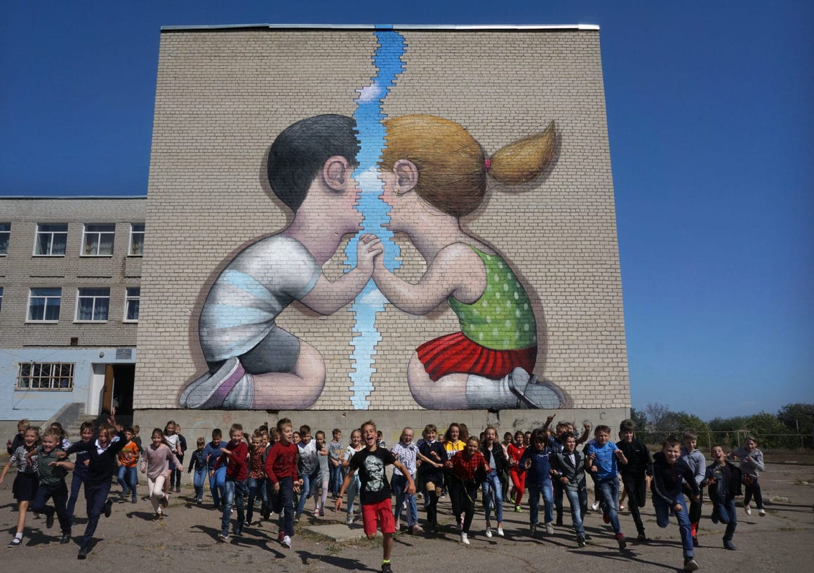 Oeuvre de street art en ukraine, deux enfants face à face seth globepainter