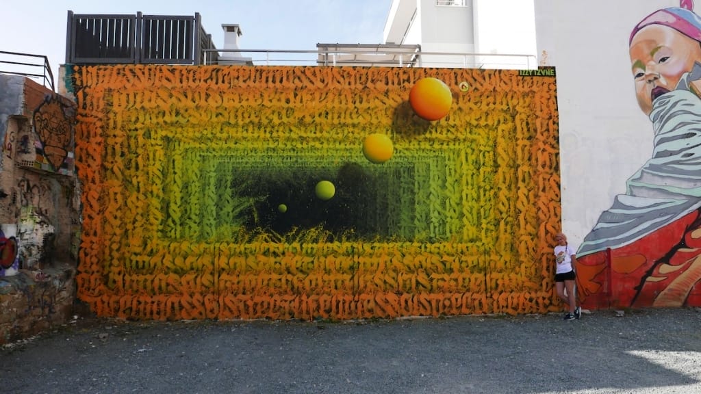 Fresque murale Izzi Izvne dans les tons orange et vert. 