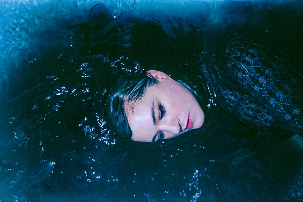 portrait julianna Barwick dans eau cheveux mouillés lèvres rosées maquillage bleu habille dentelle bleu foncé Jen Medina 