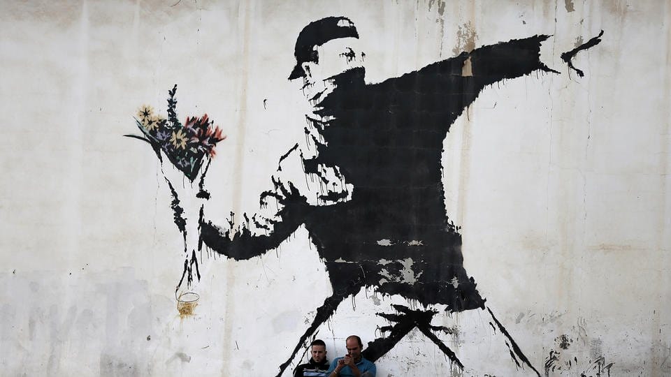 love is in the air banksy israël palestine mur homme jette bouquet de fleurs 