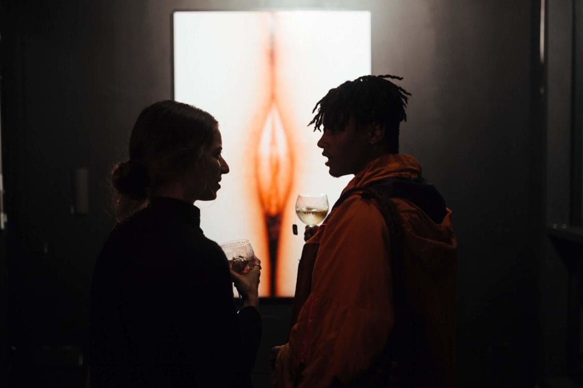 deux personne discutent face au photo vagin Peter Kaaden pour Naaked exposition