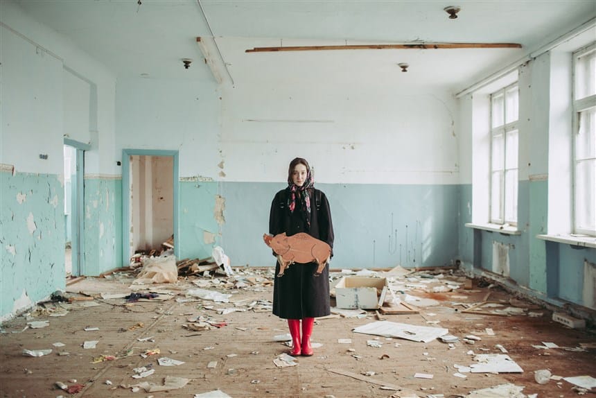 Alisa Gorshenina avec un cochon dans une salle de classe en ruine