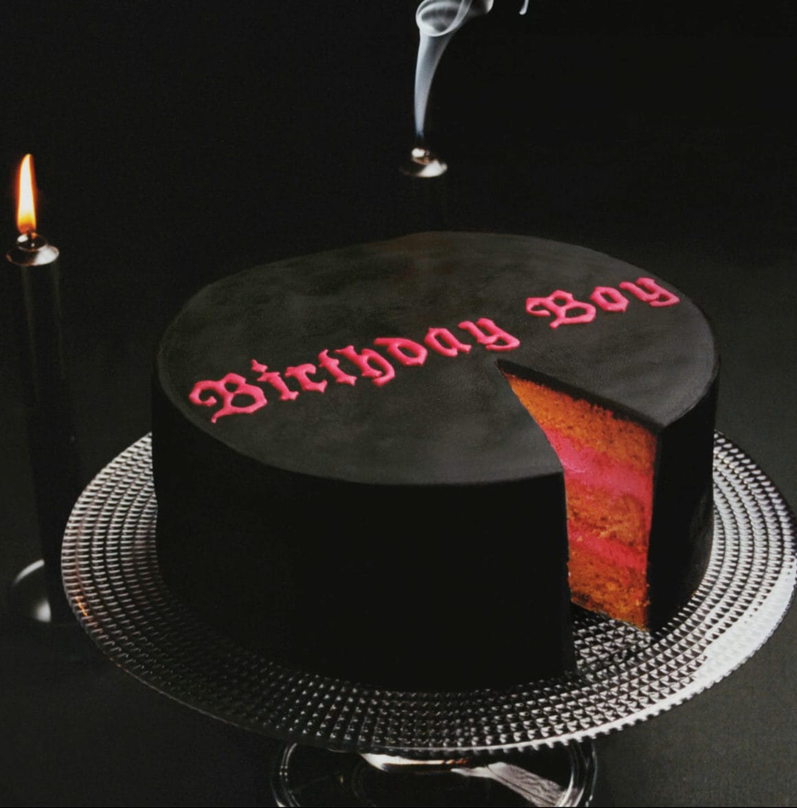 Pochette officielle de Birthday Boy, un gâteau noir avec un intérieur rosé et le titre écrit dessus en rose