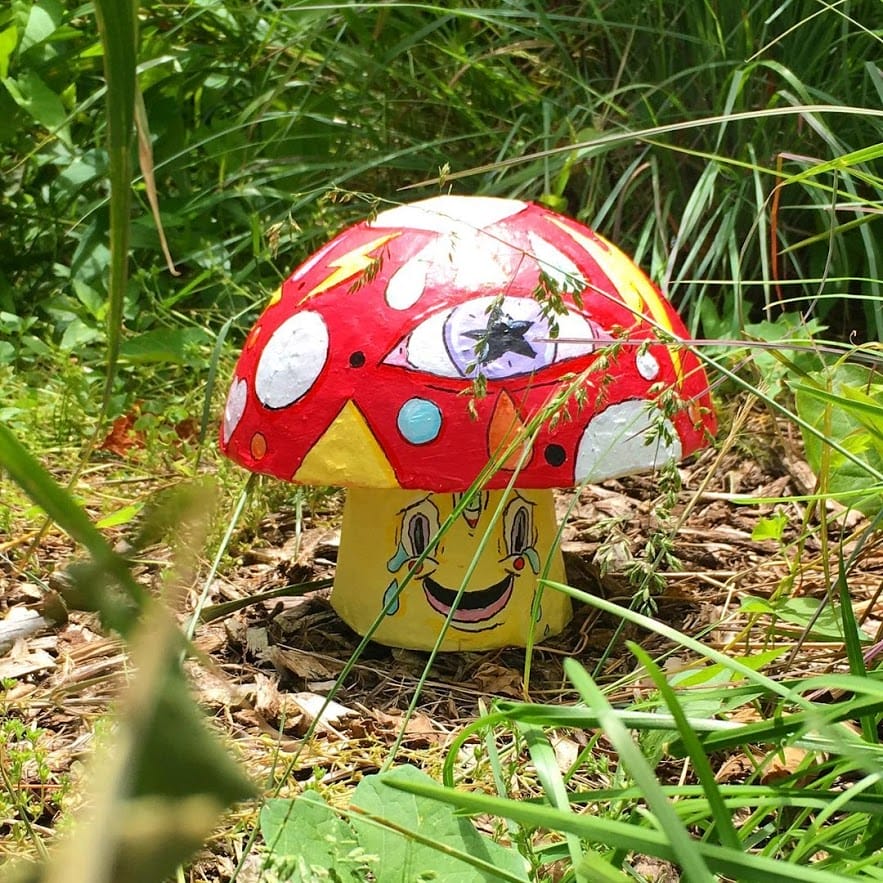 Petit champignon jaune et rouge qui pleure, caché dans l'herbe pour le Game of shrooms
