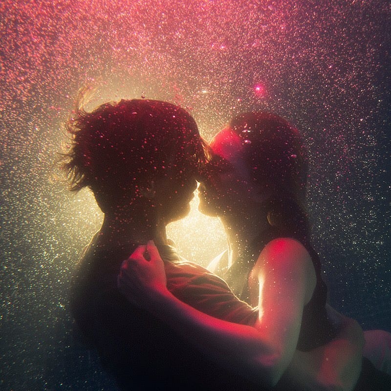 Un homme et une femme vont s'embrasser sous l'eau, une lumière rose éclaire la scène