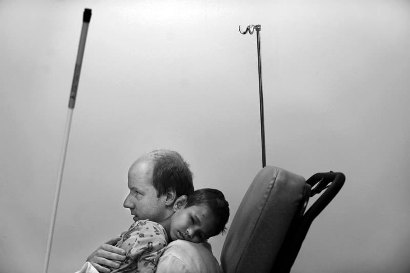 Sur une chaise d'hôpital, Jason tient Pandu dans ses bras.