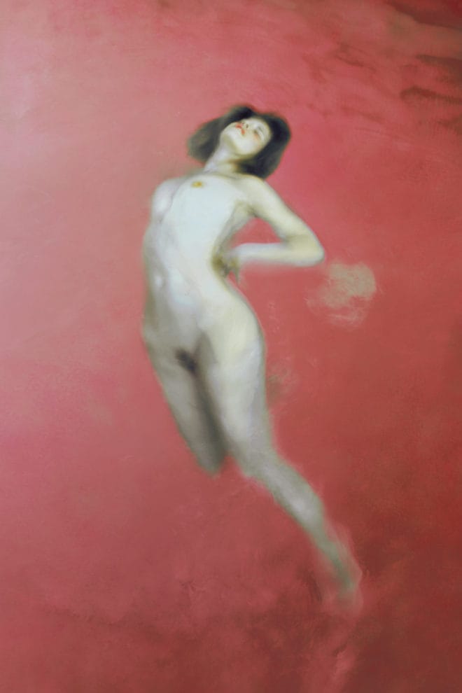 Photographie d'une femme nue dans une étendue d'eau rose.