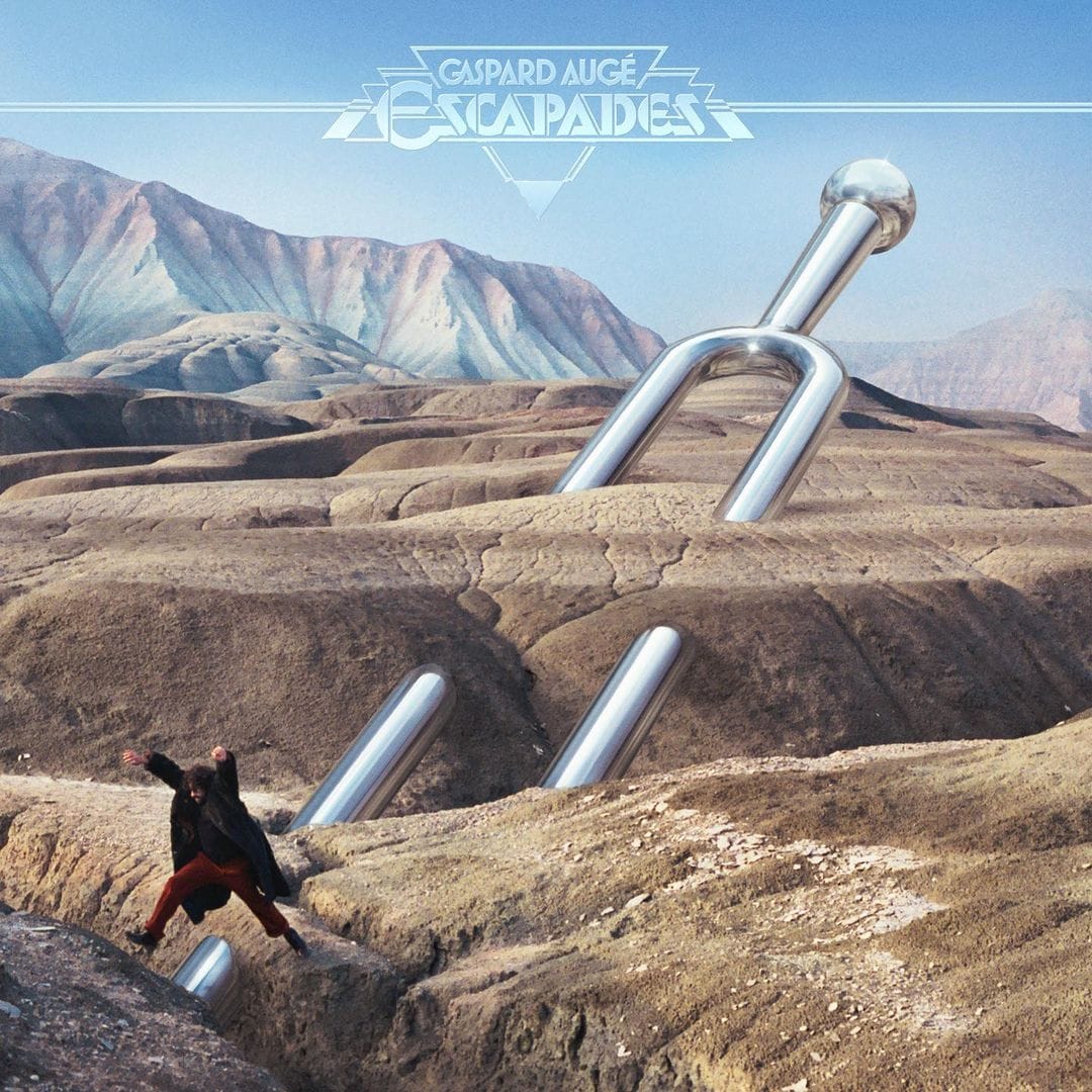 Pochette de l'album Escapades : Paysage rocailleux sur lequel se distingue un diapason chromé géant. En bas à gauche, au premier plan, Gaspard Augé quatre au dessus d'une crevasse.