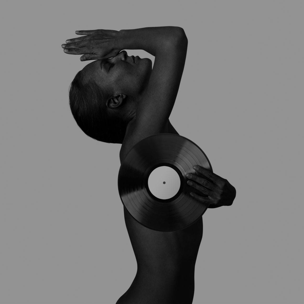 Portrait de LIA MOON, de profil et en noir et blanc. Elle tient un disque vinyl, qui lui permet de dissimuler sa poitrine.