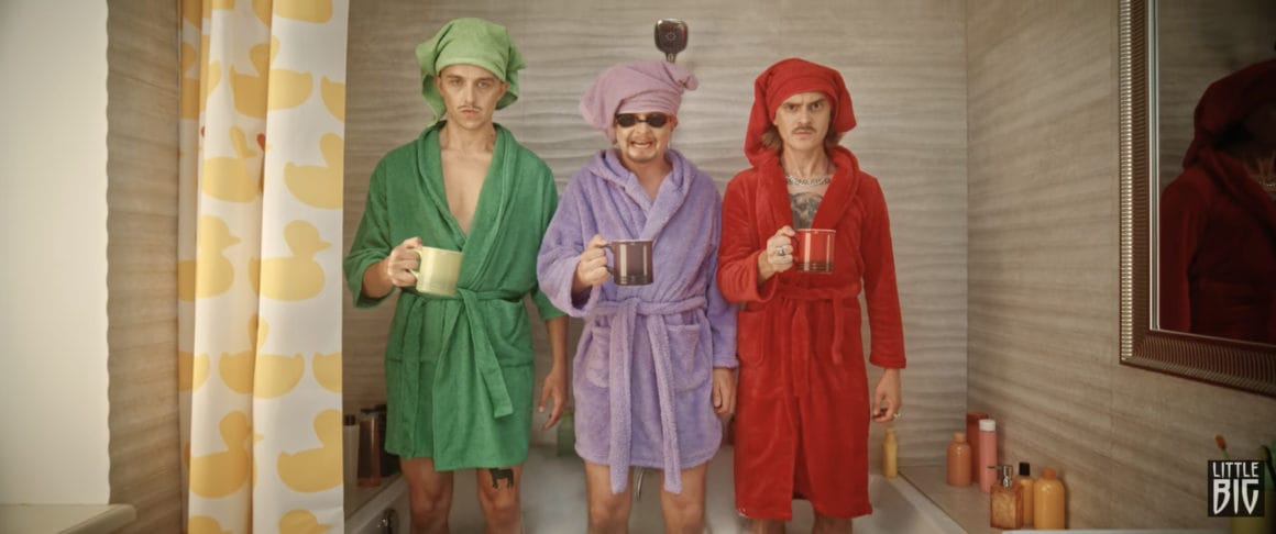 Les trois hommes sont debout dans une baignoire, en peignoir assortis à leurs pyjamas initiaux et tenant un mug dans leurs mains gauches.
