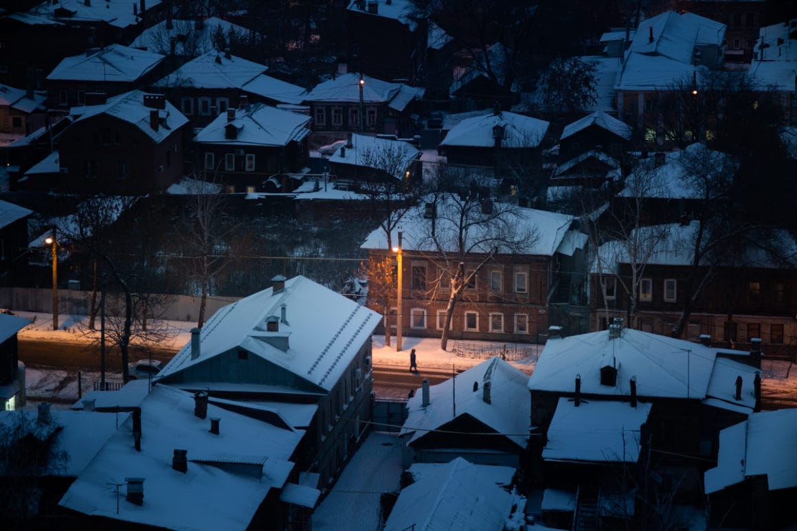 arseniy kotov photographie d'un quartier ou un individu se promène éclairé par les lampadaires