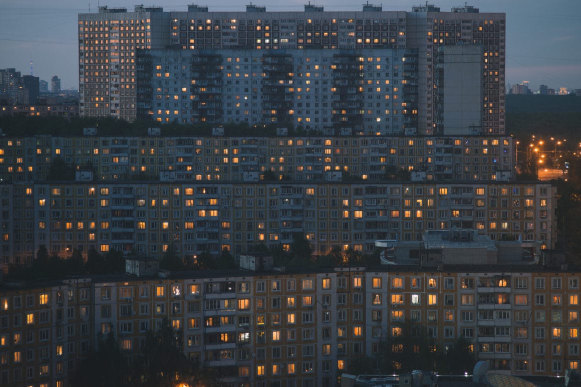 arseniy kotov photographie d'immeuble avec quelques lumières allumées