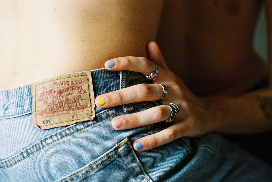 photographie argentique d'une main vernie qui touche un jean Levi's