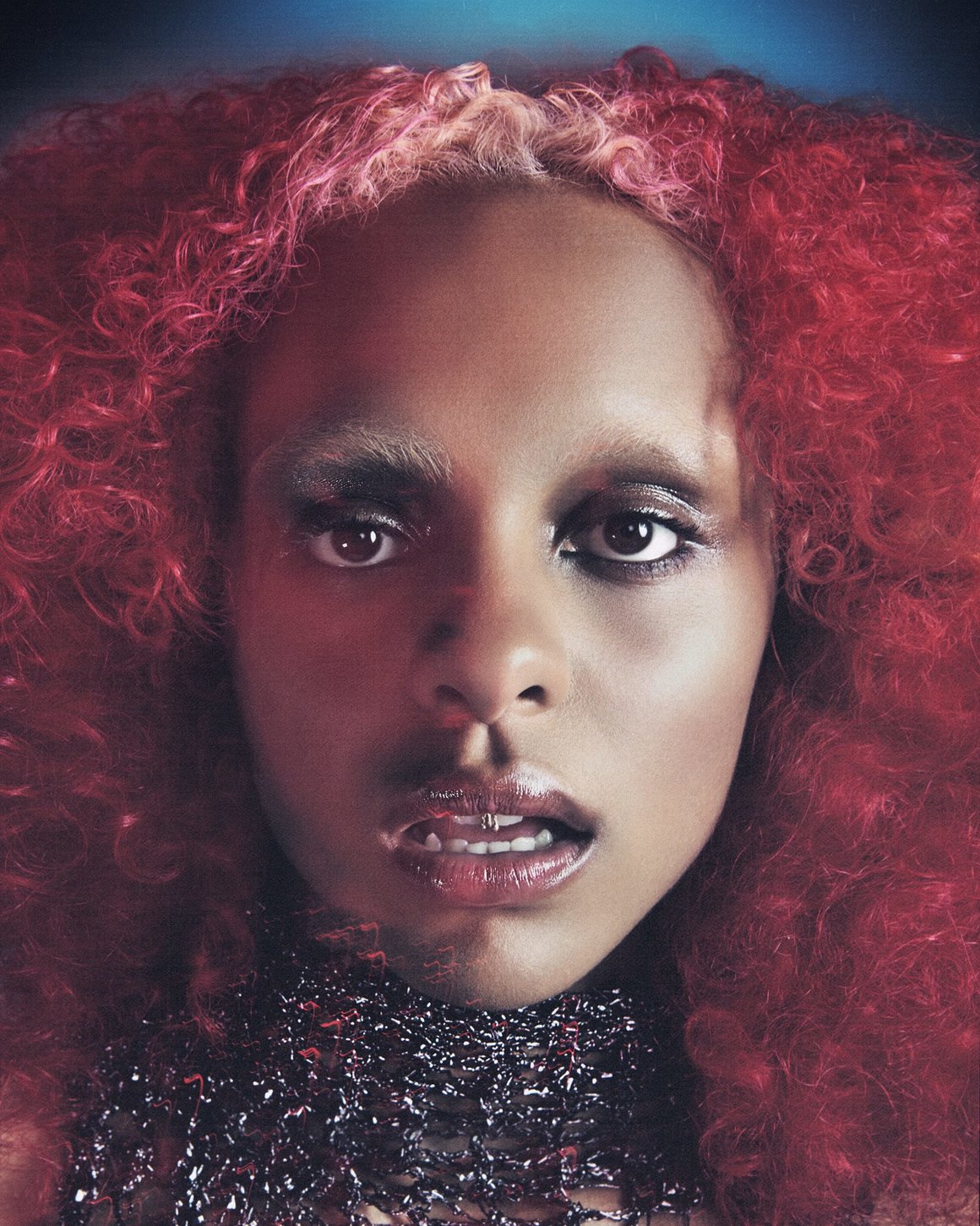 Portrait de Crystal Murray, font la teinte rouge de ses cheveux contraste avec le fond bleu.