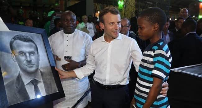 Photo d'Emmanuel Macron avec Kareem Waris Olamilekan autour de son portrait. 