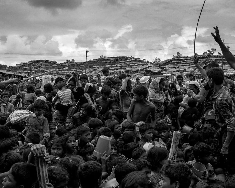 Les soldats aidés de plusieurs Rohingyas tentent de contrôler la distribution et essaient de faire asseoir la foule pour calmer les tensions.