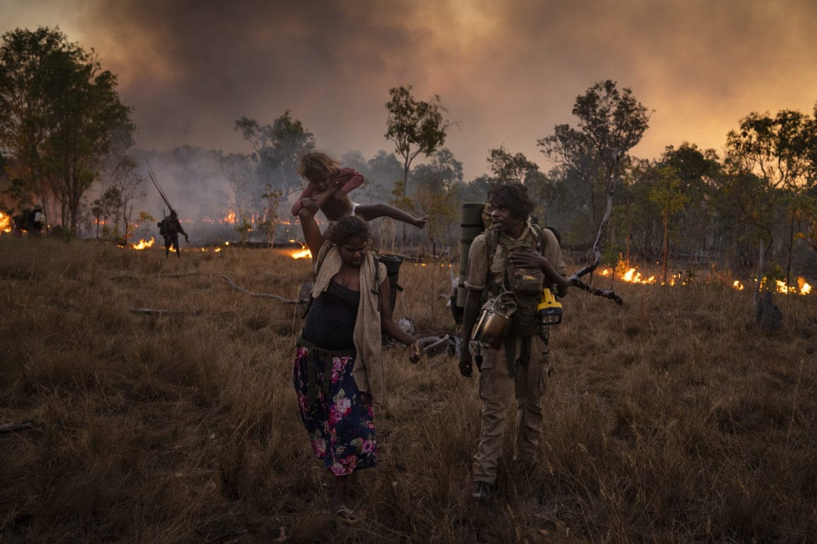 Une famille s'écarte du feu volontairement déclenché dans le bush