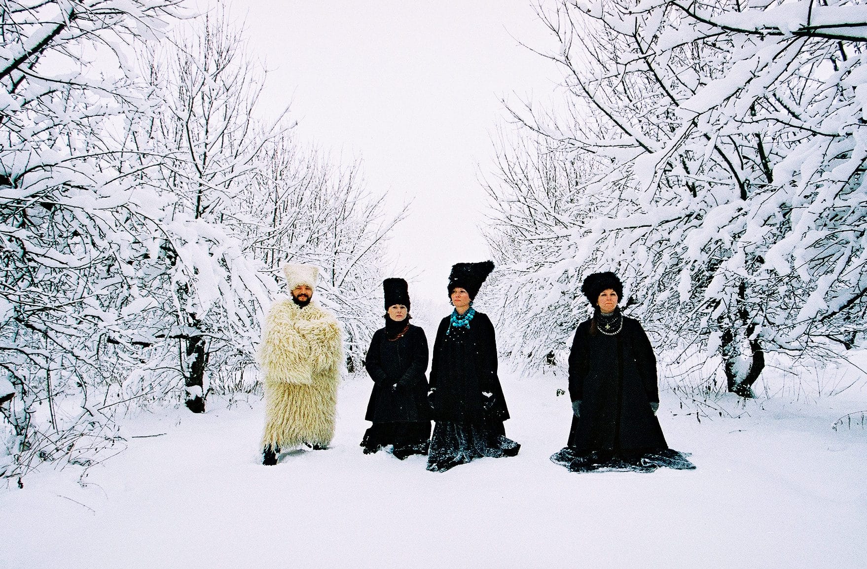 ici le groupe dakhabrakha pose dans la neige vêtus de fourrures noires et blanches