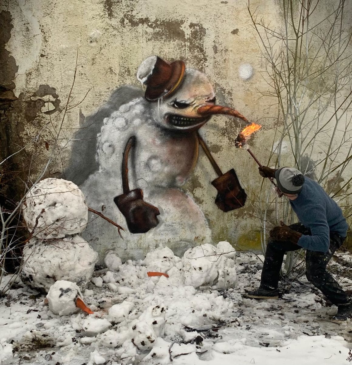 Bonhomme de neige peint par GrafoDeco qui se défend avec une torche
