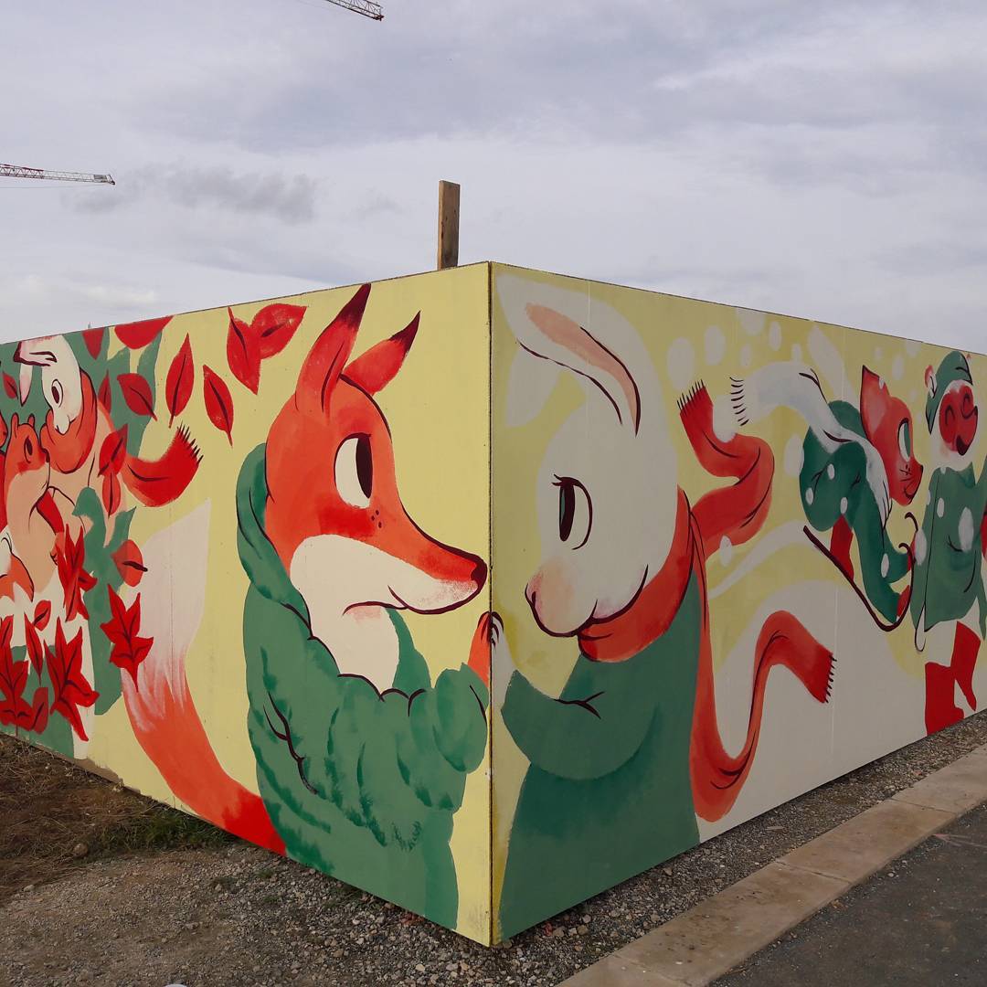Cette fresque représente un renard et un lapin qui se tiennent les mains, chacun d'un côté d'un mur.