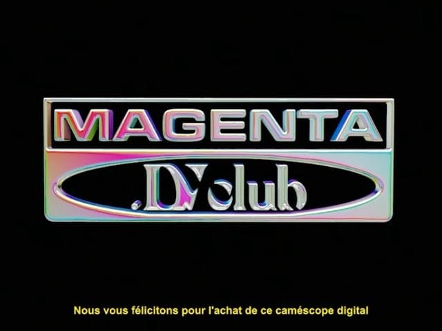 "Magenta. DV club" est écrit sur un fond noir avec une calligraphie du style des années 80/90. On lit aussi un sous titre jaune "Nous vous félicitons pour l'achat de ce caméscope digital" . 