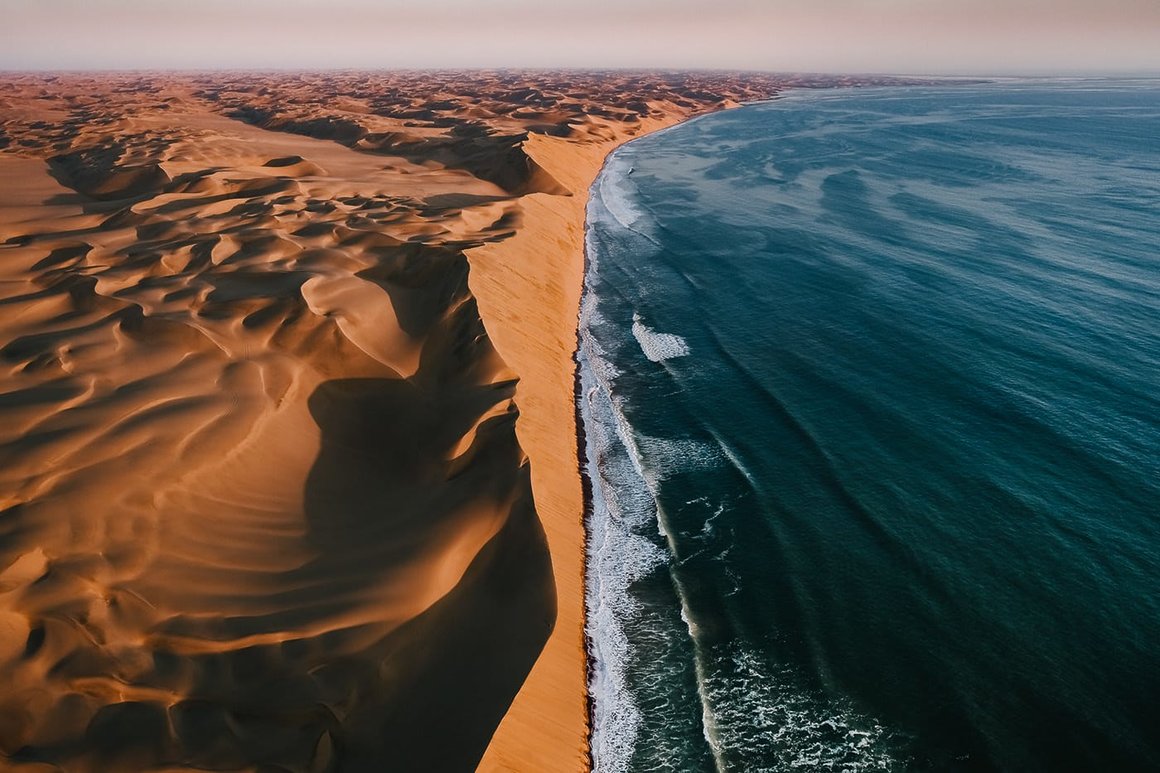 Tom Hegen : Dunes de sables en Namibie se fusionnant avec l'océan atlantique.
