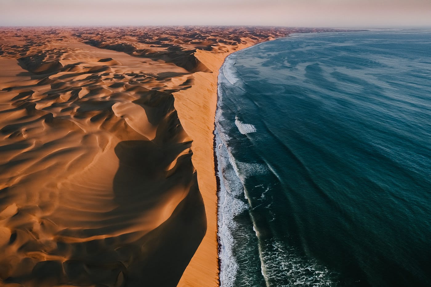 Tom Hegen : Dunes de sables en Namibie se fusionnant avec l'océan atlantique.