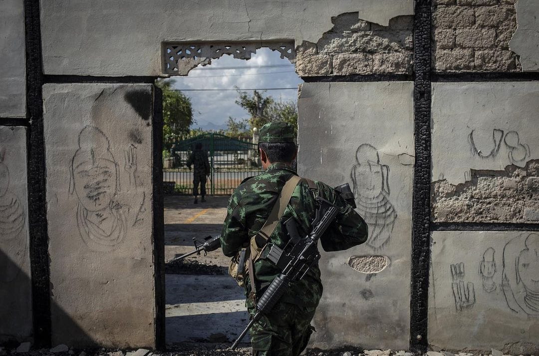 Un soldat en uniforme traverse un mur cachant un tas de débris. Ce mur s'avèrait être sa maison