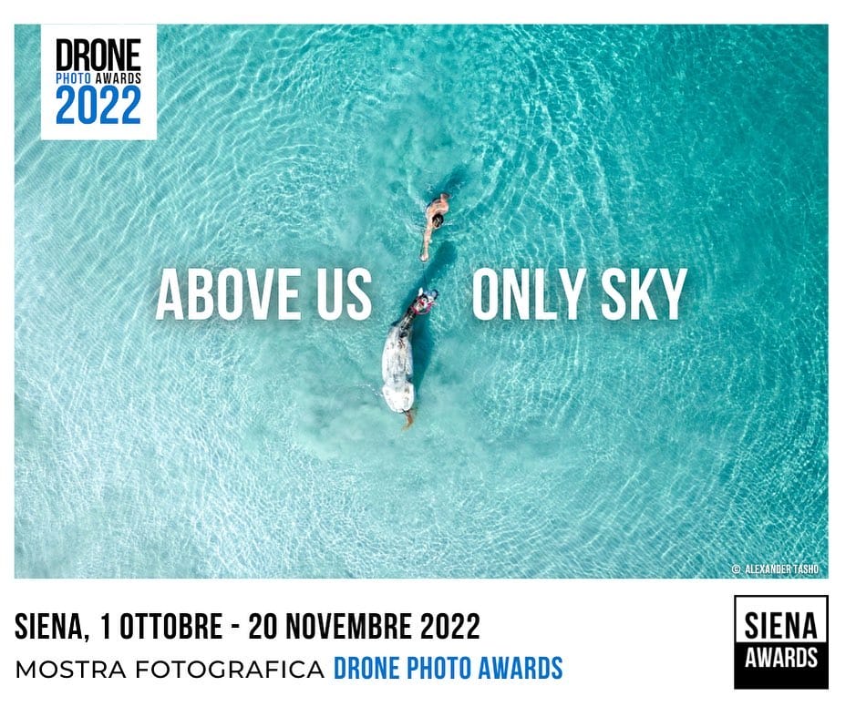 Affiche  Drone Photo Awards 2022, un homme attrape un poisson dans une mer bleue paradisiaque 