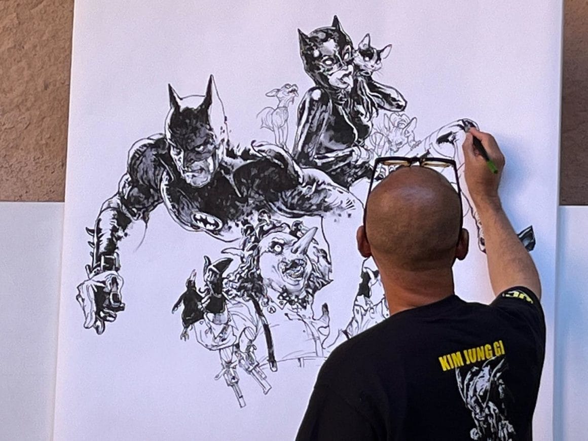 L'artiste Kim Jung Gi est en train de dessiner une oeuvre mettant en scène l'univers du comics Batman.
