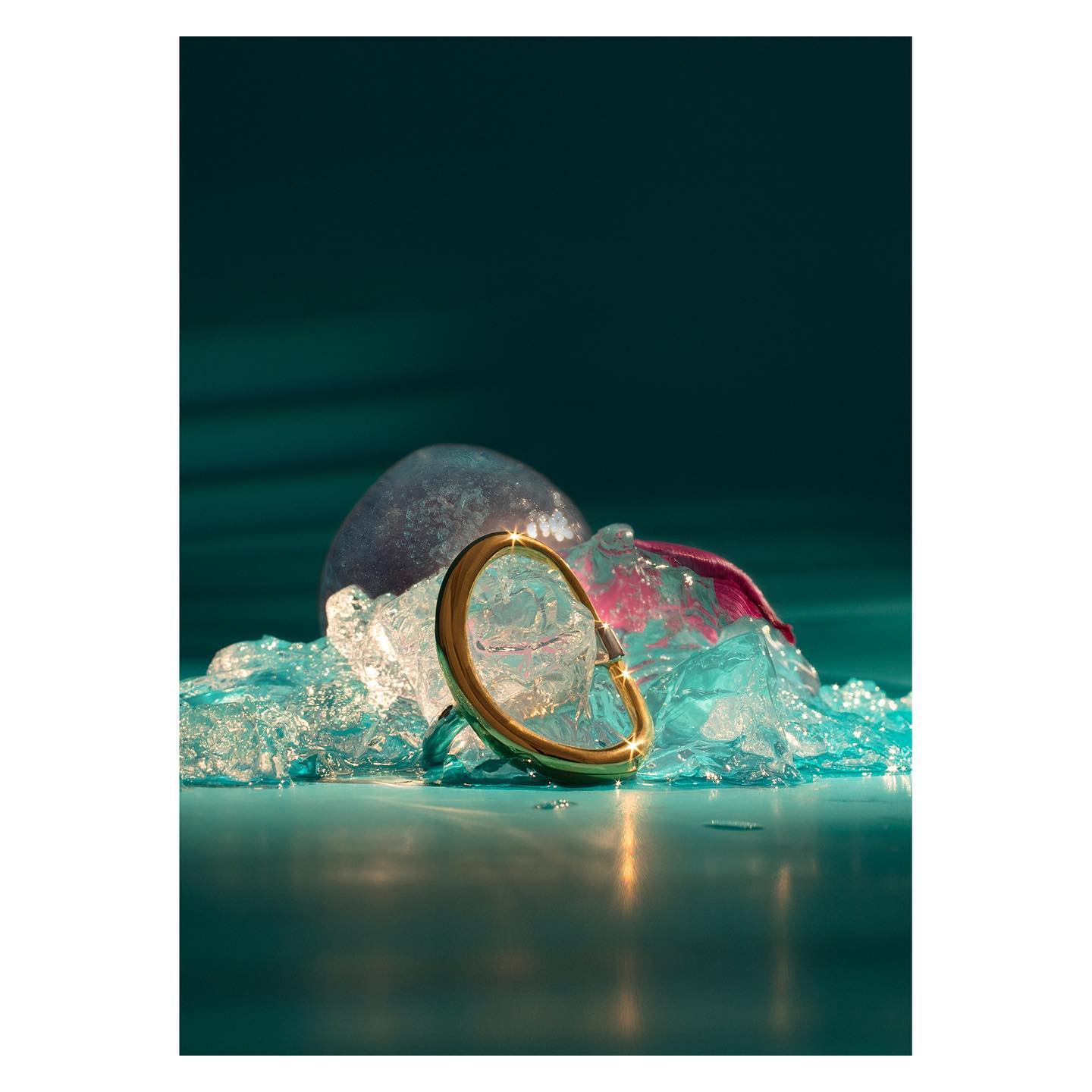 Photo d'un bracelet or posé sur une structure de glace bleu