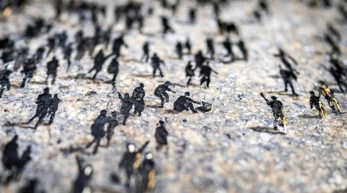 Oeuvre de Pejac représentant des dizaines de petits personnages peints sur du béton