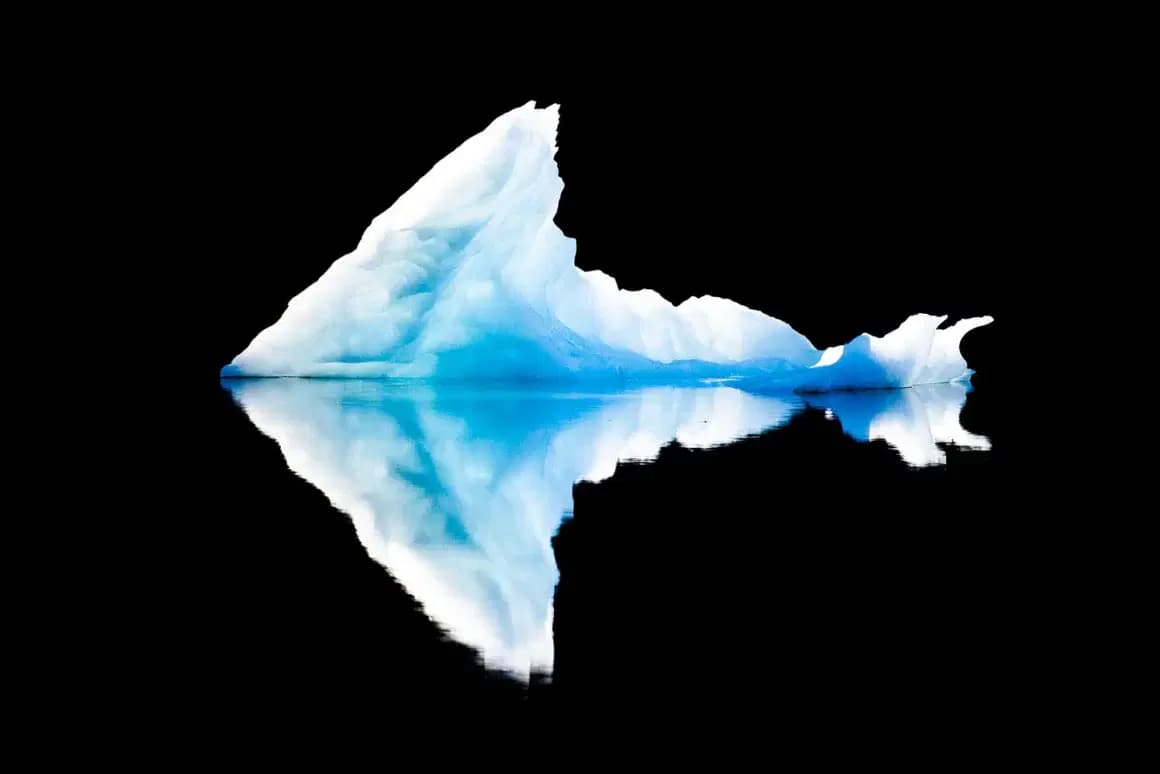 Photographie d'un iceberg qui se reflète dans l'eau.